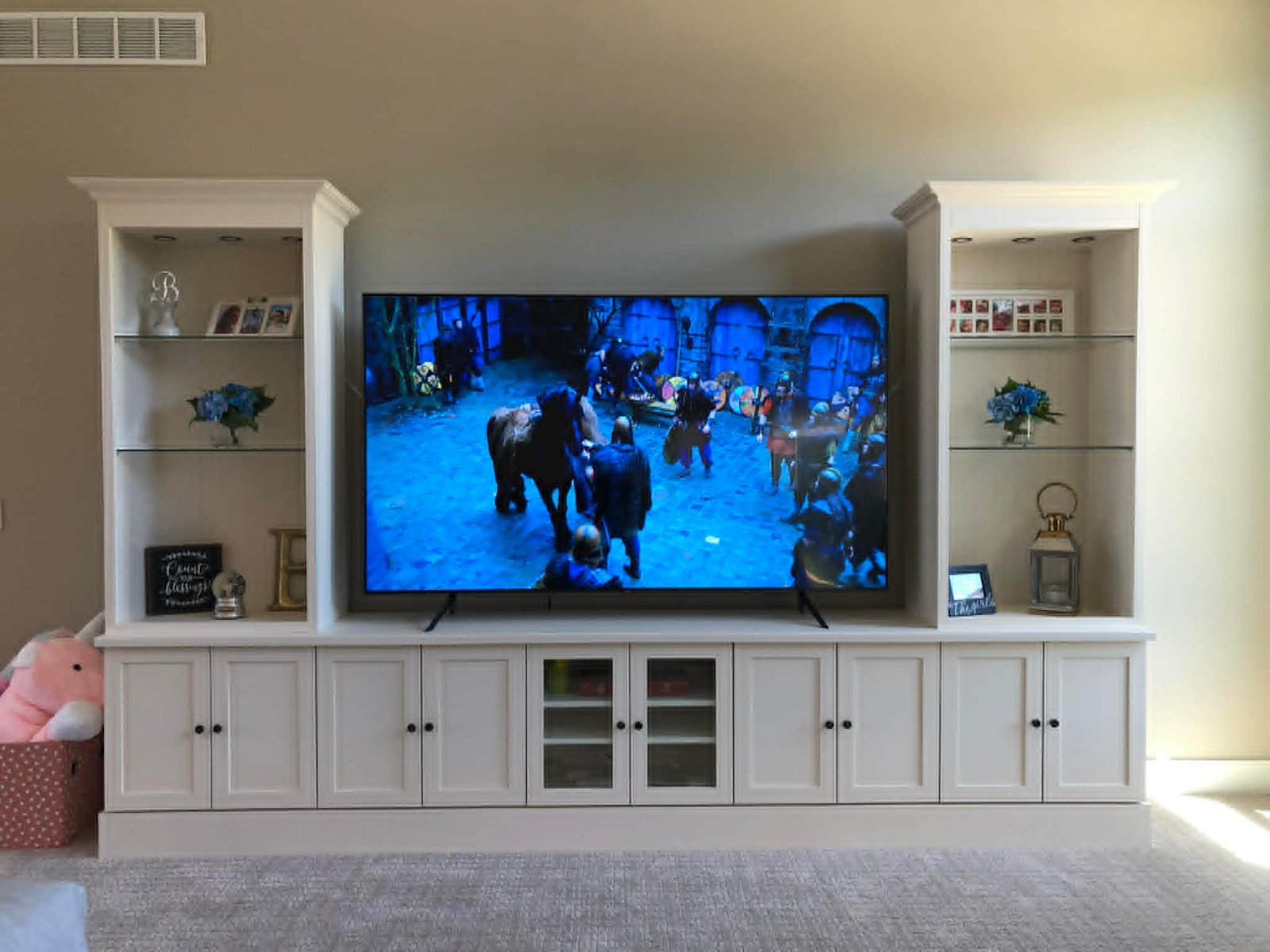Built-in entertainment wall with base cabinets and tall display shelving