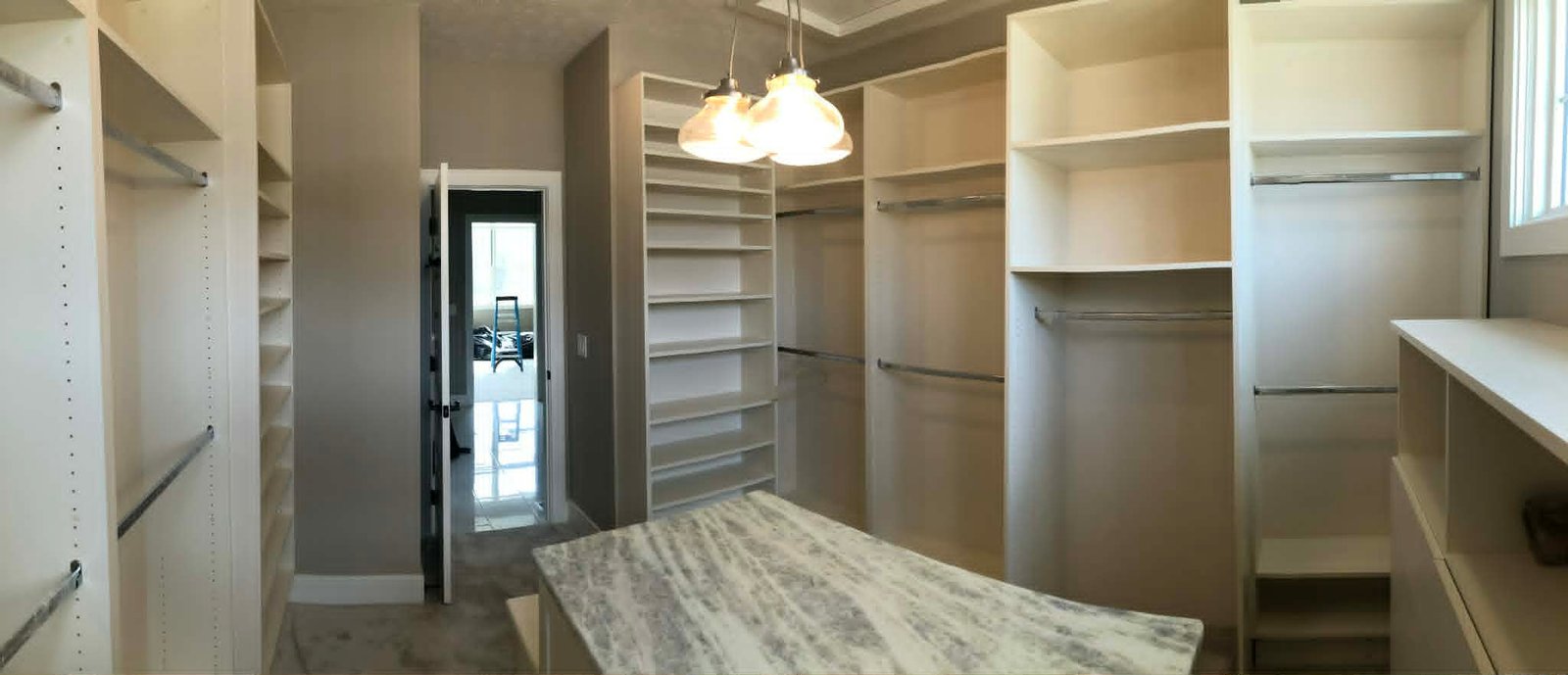 Custom walk-in closet with hanging sections, shelving, and center island
